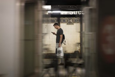 man standing looking at mobile snooping security