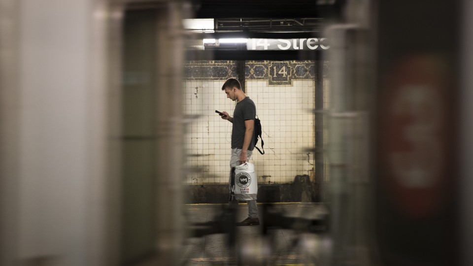 man standing looking at mobile snooping security